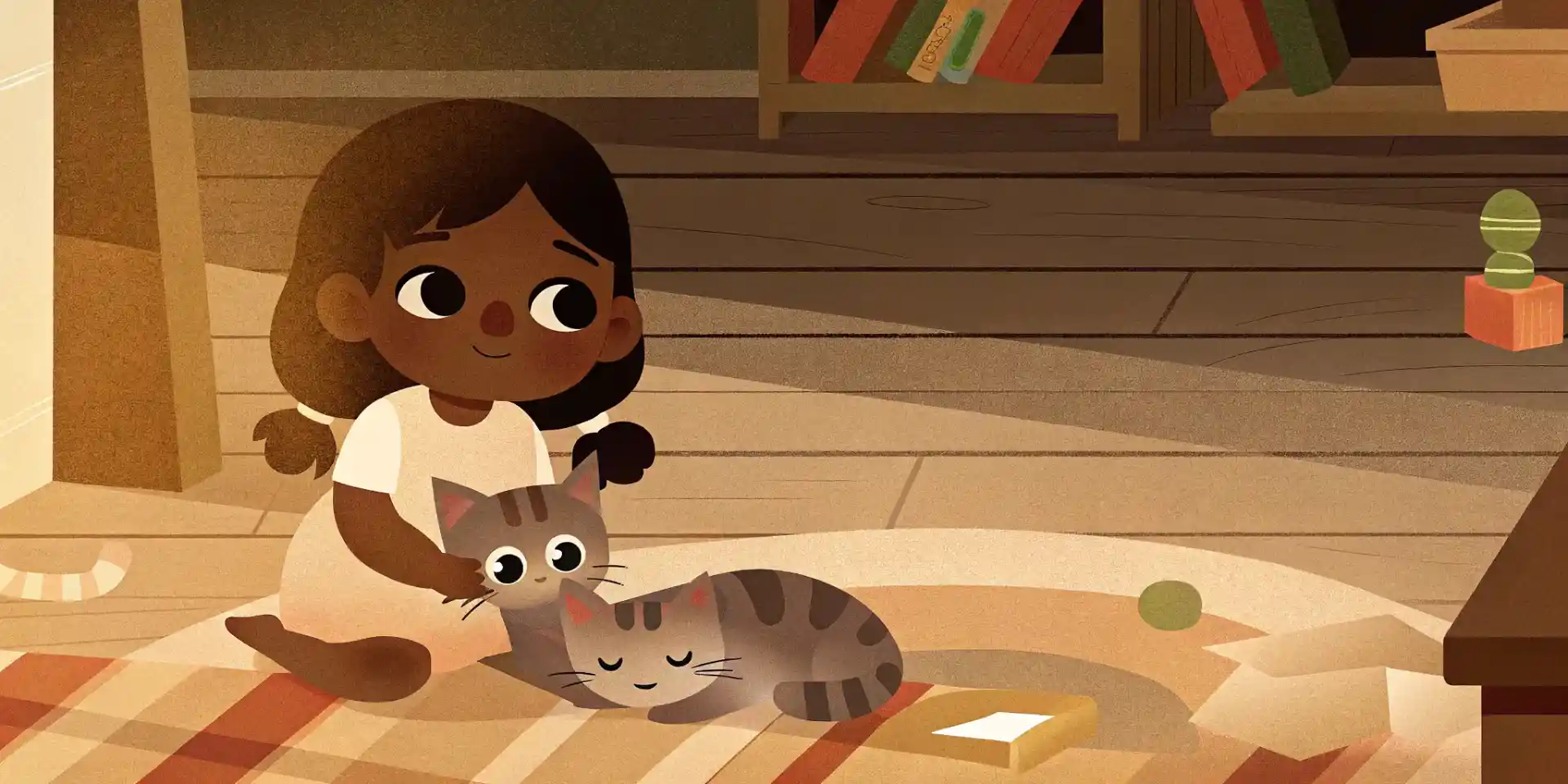 A young girl gently petting a tabby kitten while sitting on the floor