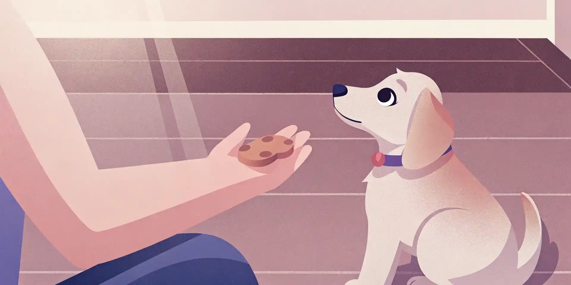 A golden retriever puppy sitting attentively while its owner holds a treat